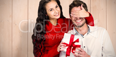 Composite image of young woman covering eyes of partner holding