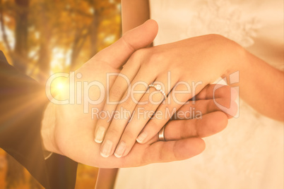 Composite image of cropped image of newly wed couple holding han