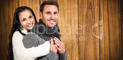 Composite image of smiling couple hugging and looking at camera