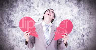 Composite image of geeky businessman crying and holding broken h