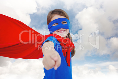 Composite image of smiling masked girl pretending to be superher