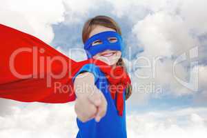 Composite image of smiling masked girl pretending to be superher