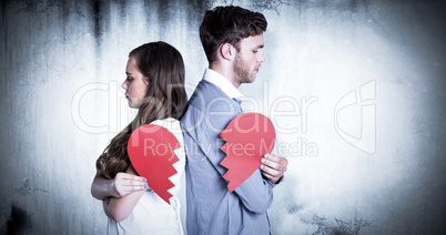 Composite image of side view of young couple holding broken hear