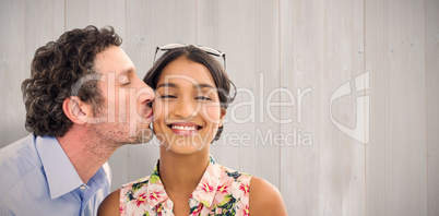 Composite image of man kissing woman on the cheek