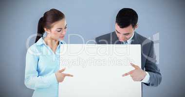 Composite image of business partners pointing at sign they are p