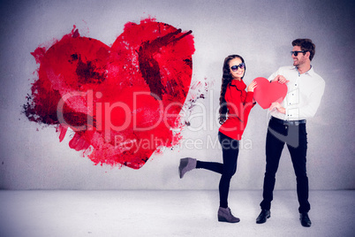 Composite image of smiling couple with sunglasses holding paper