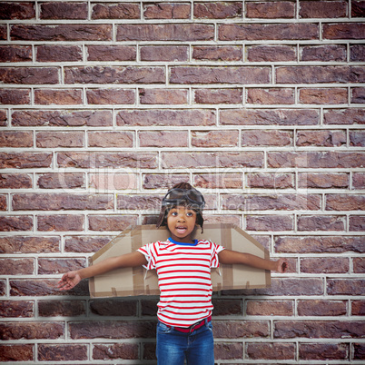 Composite image of smiling boy pretending to be pilot