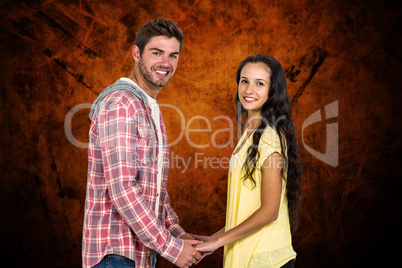 Composite image of smiling couple holding their hands and lookin