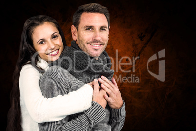 Composite image of smiling couple hugging and looking at camera