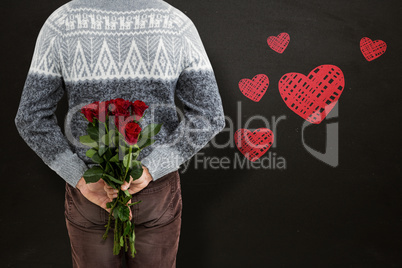 Composite image of mid section of man hiding red roses