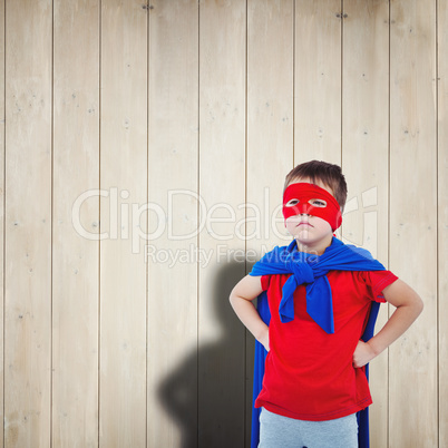 Composite image of masked boy pretending to be superhero