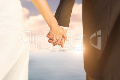 Composite image of close up of cute young newlyweds holding thei