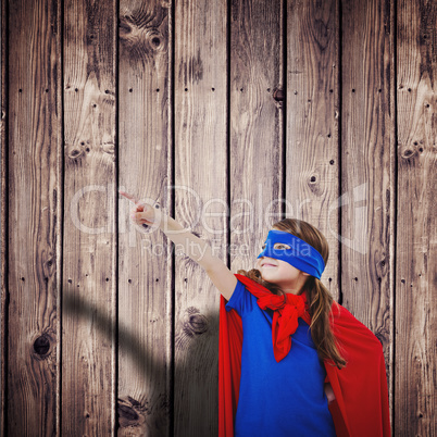 Composite image of masked girl pretending to be superhero