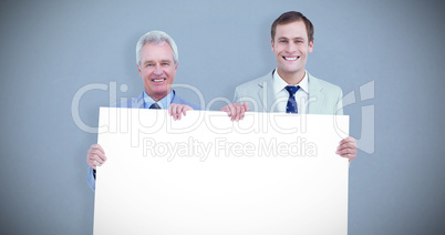 Composite image of smiling tradesmen holding blank sign