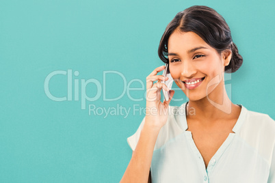 Composite image of smiling businesswoman using mobile phone