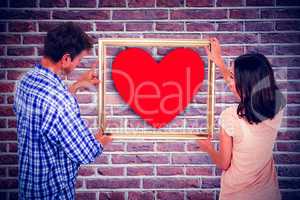 Composite image of couple holding picture frame