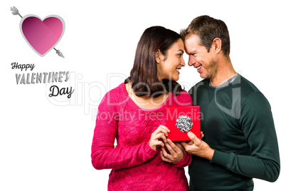 Composite image of happy couple holding gift box