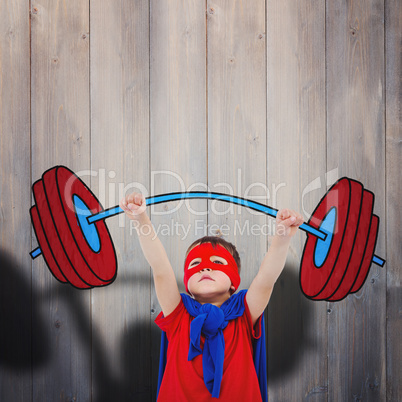 Composite image of little boy holding dumbbell