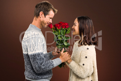 Composite image of romantic couple holding red roses