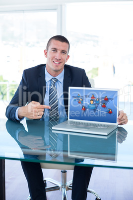 Composite image of smiling businessman pointing at laptop screen