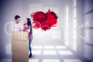 Composite image of smiling couple holding on boxes with piggy sa