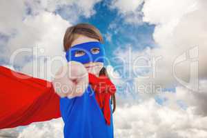 Composite image of masked girl pretending to be superhero