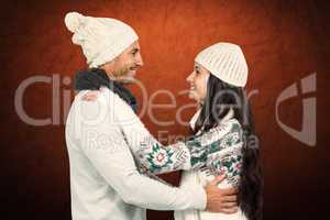Composite image of smiling couple hugging and looking at each ot