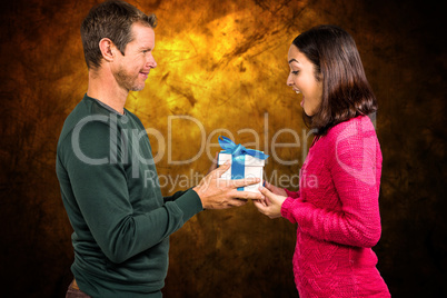Composite image of excited girlfriend taking gift from boyfriend