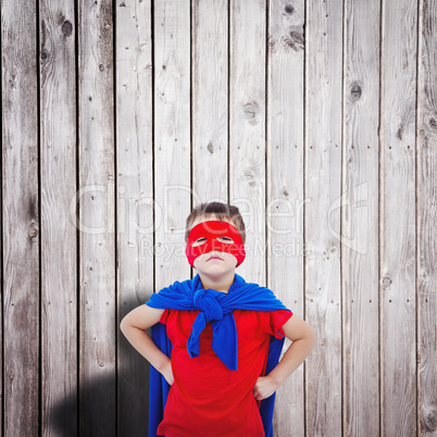 Composite image of masked boy pretending to be superhero