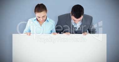 Composite image of business partners looking down at sign they a