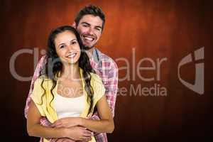 Composite image of happy couple hugging and looking at camera