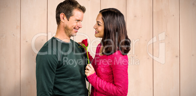 Composite image of smiling couple with red rose