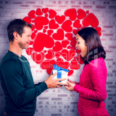 Composite image of excited girlfriend taking gift from boyfriend