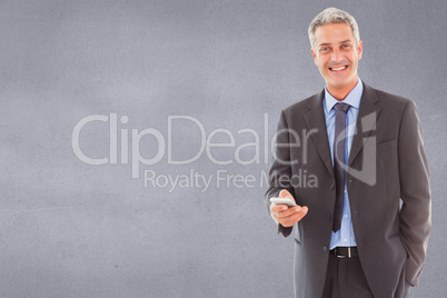 Composite image of happy business man using smartphone