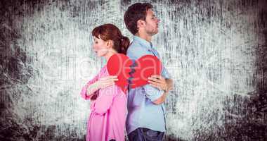 Composite image of couple holding a broken heart