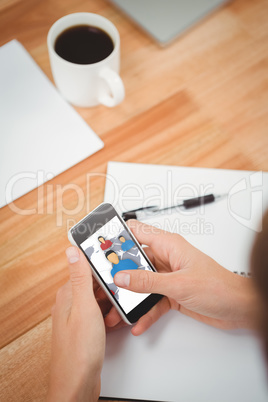 Composite image of businessman using smartphone at desk in offic