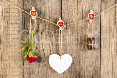 Red rose with white shape heart and chocolate on wooden