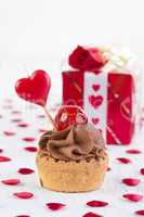 Cupcake with cherry in front of gift box