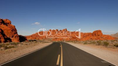 Long and empty road through the Valley of Fire National Park .