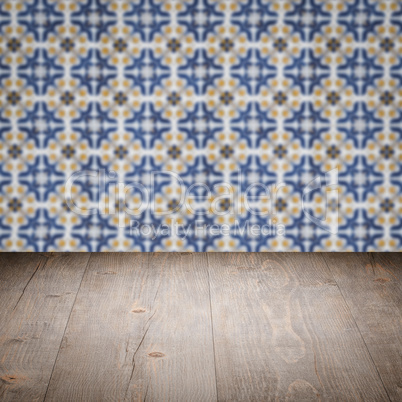 Wood table top and blur vintage ceramic tile pattern wall