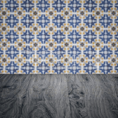 Wood table top and blur vintage ceramic tile pattern wall