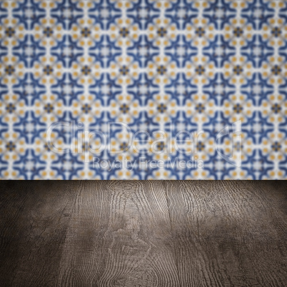 Wood table top and blur vintage ceramic tile pattern wall