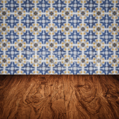Wood table top and blur vintage ceramic tile pattern wall Wood table top and blur vintage ceramic tile pattern wall