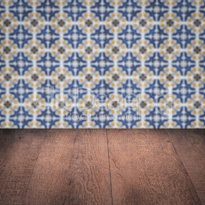 Wood table top and blur vintage ceramic tile pattern wall