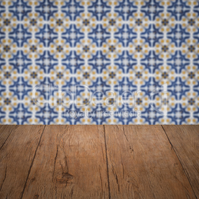 Wood table top and blur vintage ceramic tile pattern wall Wood table top and blur vintage ceramic tile pattern wall