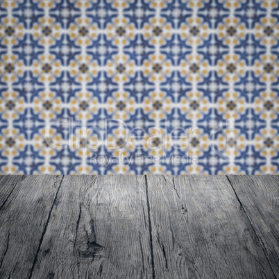 Wood table top and blur vintage ceramic tile pattern wall Wood table top and blur vintage ceramic tile pattern wall