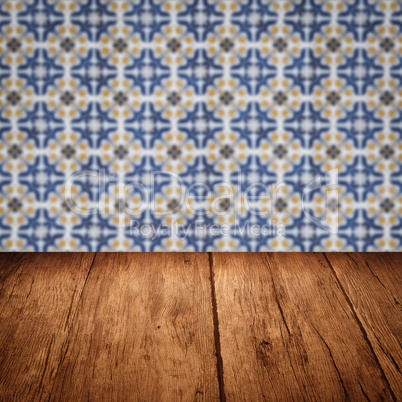 Wood table top and blur vintage ceramic tile pattern wall