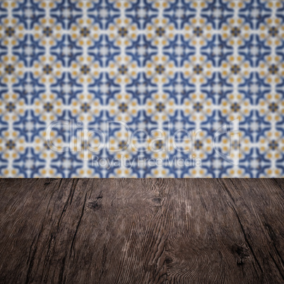 Wood table top and blur vintage ceramic tile pattern wall