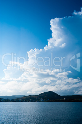 Large billowing clouds above coastal village