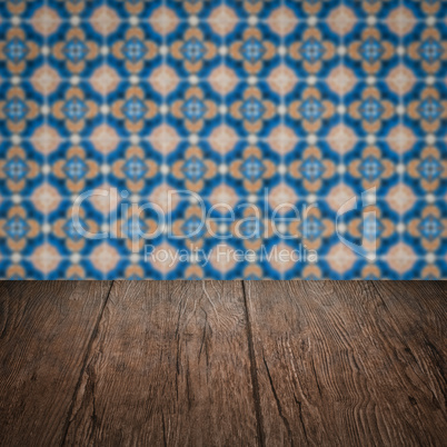 Wood table top and blur vintage ceramic tile pattern wall Wood table top and blur vintage ceramic tile pattern wall